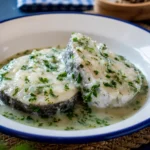 Plate of traditional Merluza en Salsa Verde with fresh hake and sauce